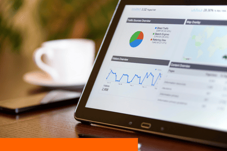 Imagem de um tablet mostrando gráficos e números de avanço do um site